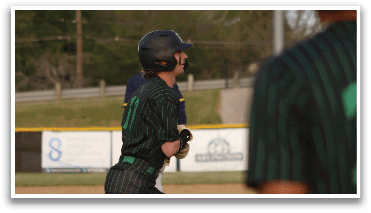 A baseball player in a green and black striped uniform is swinging a bat. Description generated by AI