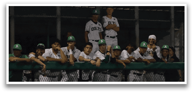 A group of baseball players wearing green and white uniforms. Description generated by AI