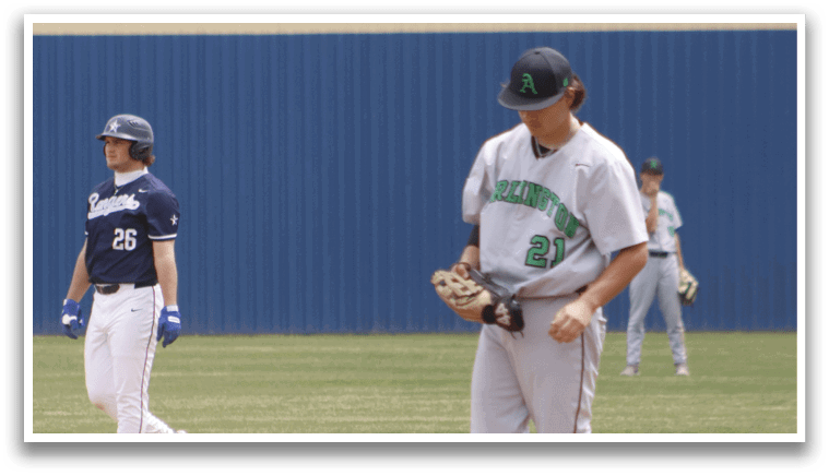 A baseball player in a white and green shirt is standing on the field. Description generated by AI