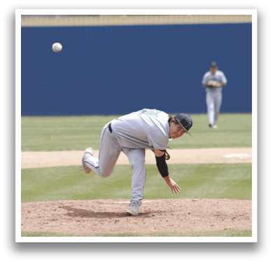 A baseball player in a grey uniform is bending over to catch a ball. Description generated by AI