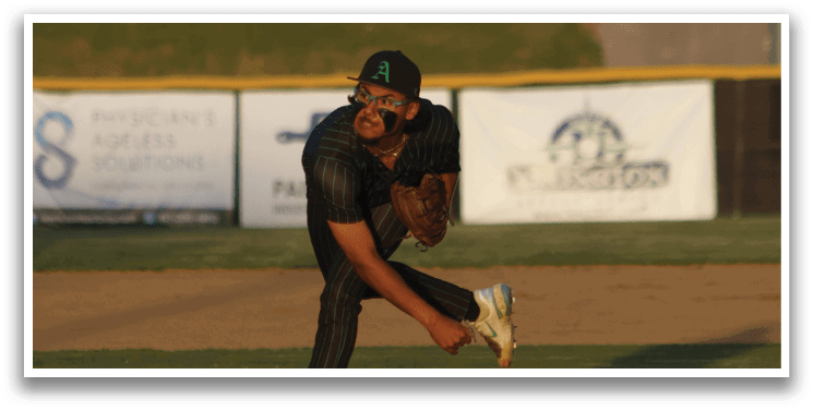 A baseball player in a black shirt and green hat is pitching a ball. Description generated by AI