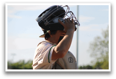 A baseball player wearing a helmet and catcher's gear. Description generated by AI