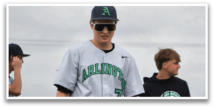 A boy wearing a baseball uniform with the number 7 on it. Description generated by AI