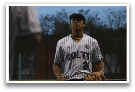 A baseball player wearing a green and white uniform. Description generated by AI