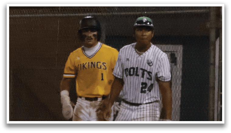 Two baseball players standing on a field. Description generated by AI