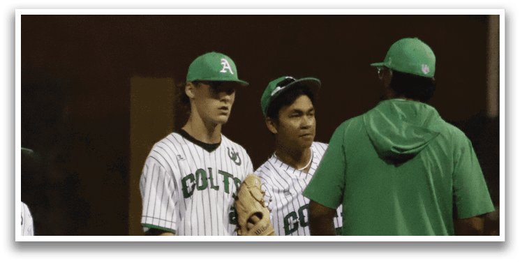 A group of baseball players standing on a field. Description generated by AI