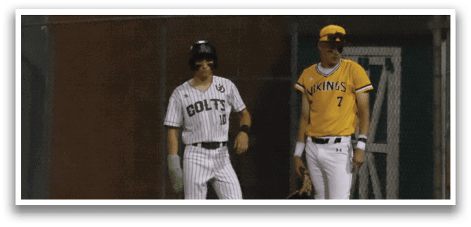A baseball player wearing a yellow shirt and a black cap. Description generated by AI
