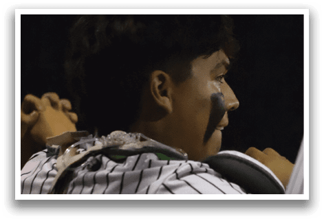 A person wearing a baseball uniform. Description generated by AI