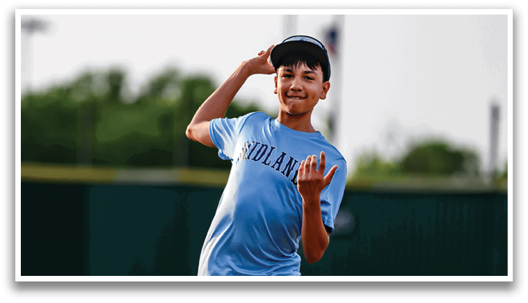 A boy in a blue shirt and shorts is throwing a baseball. Description generated by AI