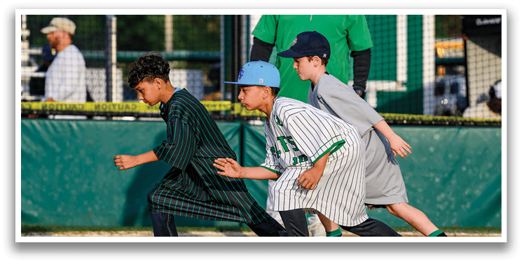 A boy wearing a striped shirt running on a baseball field. Description generated by AI