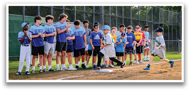 A group of children are standing on a baseball field. Description generated by AI
