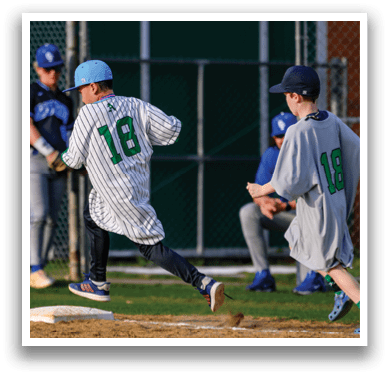 A boy in a blue hat and a jersey with the number 18 on it is running towards a base. Description generated by AI