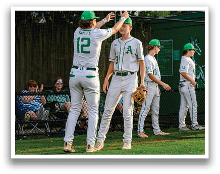 A group of baseball players wearing white uniforms. Description generated by AI