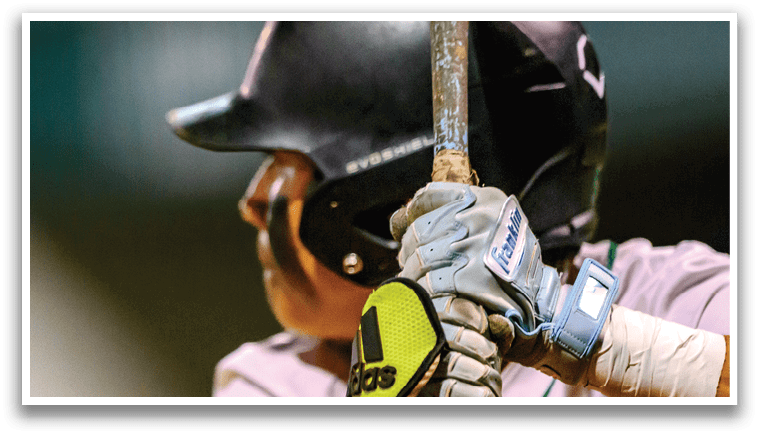 A baseball player is holding a bat and wearing a helmet. Description generated by AI