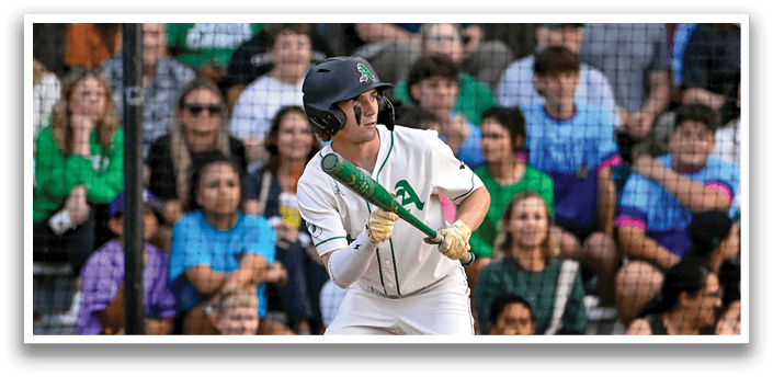 A baseball player in a white uniform holding a bat. Description generated by AI
