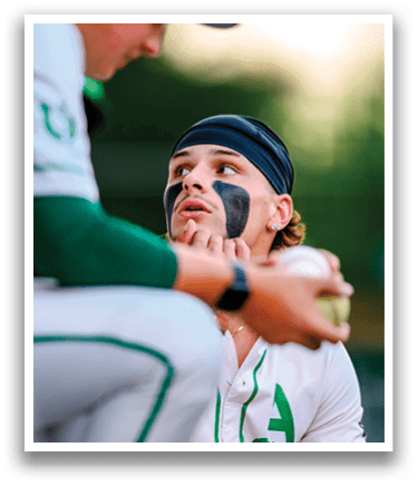 A baseball player with a black face mask. Description generated by AI