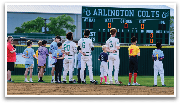A group of people standing on a baseball field. Description generated by AI
