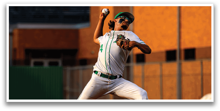 A baseball player in a white uniform is pitching a ball. Description generated by AI