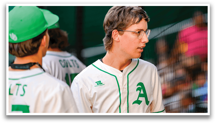 A baseball player wearing a green and white uniform. Description generated by AI
