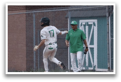 A baseball player wearing a green shirt and white pants. Description generated by AI