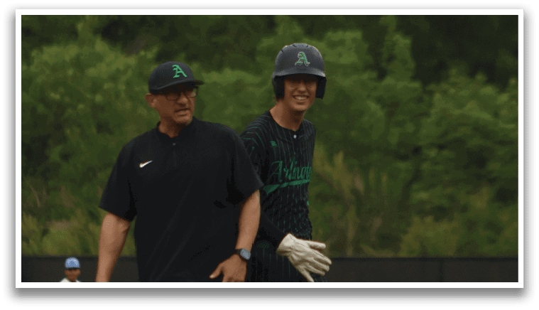 Two men standing on a baseball field. Description generated by AI