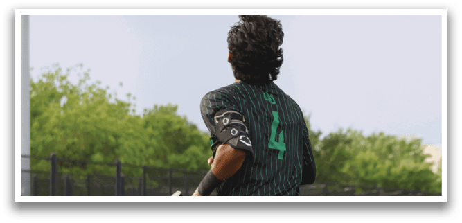 A person wearing a green and black shirt and black gloves. Description generated by AI