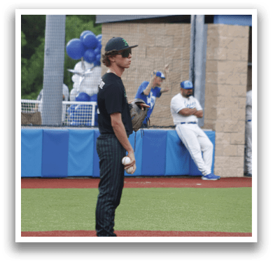 A baseball player is standing on the field holding a baseball. Description generated by AI