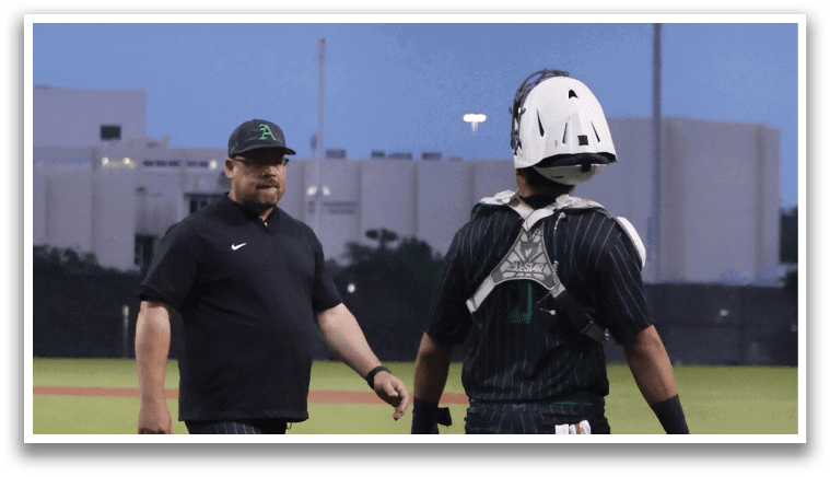 Two men standing on a baseball field. Description generated by AI