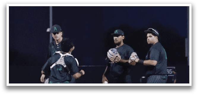 Three men standing on a baseball field. Description generated by AI