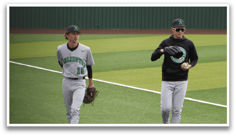 Two men standing on a baseball field. Description generated by AI