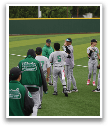 A group of baseball players standing on a field. Description generated by AI