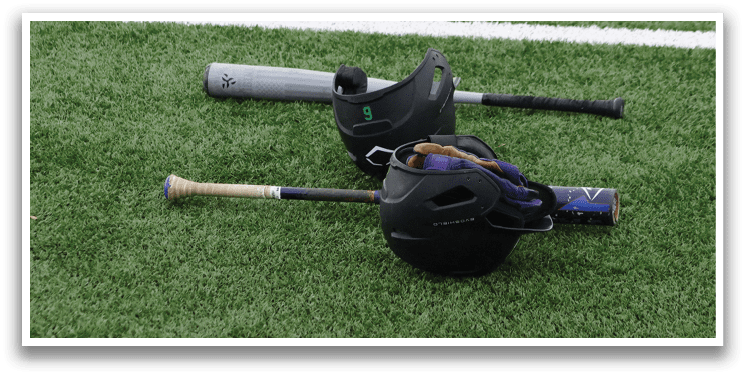 A baseball bat and helmet on the grass. Description generated by AI