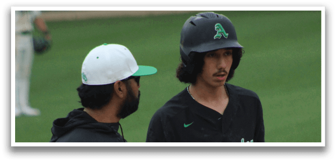 Two men standing on a baseball field. Description generated by AI