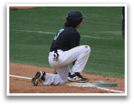 A baseball player is kneeling on the ground. Description generated by AI