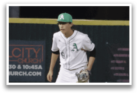 A baseball player in a white uniform is standing on a field. Description generated by AI