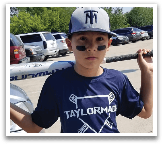 A boy wearing a blue shirt with a baseball bat. Description generated by AI