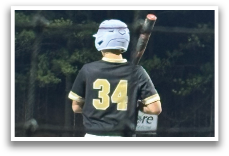 A baseball player in a black and white uniform is holding a bat, ready to swing. AI generated content