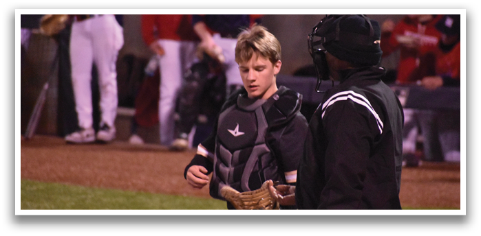 A young boy wearing a baseball glove is standing on a field with an umpire and other players. AI generated content