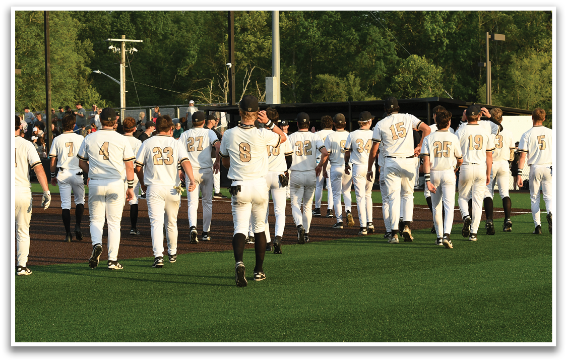 A group of baseball players walking on a field. Description generated by AI