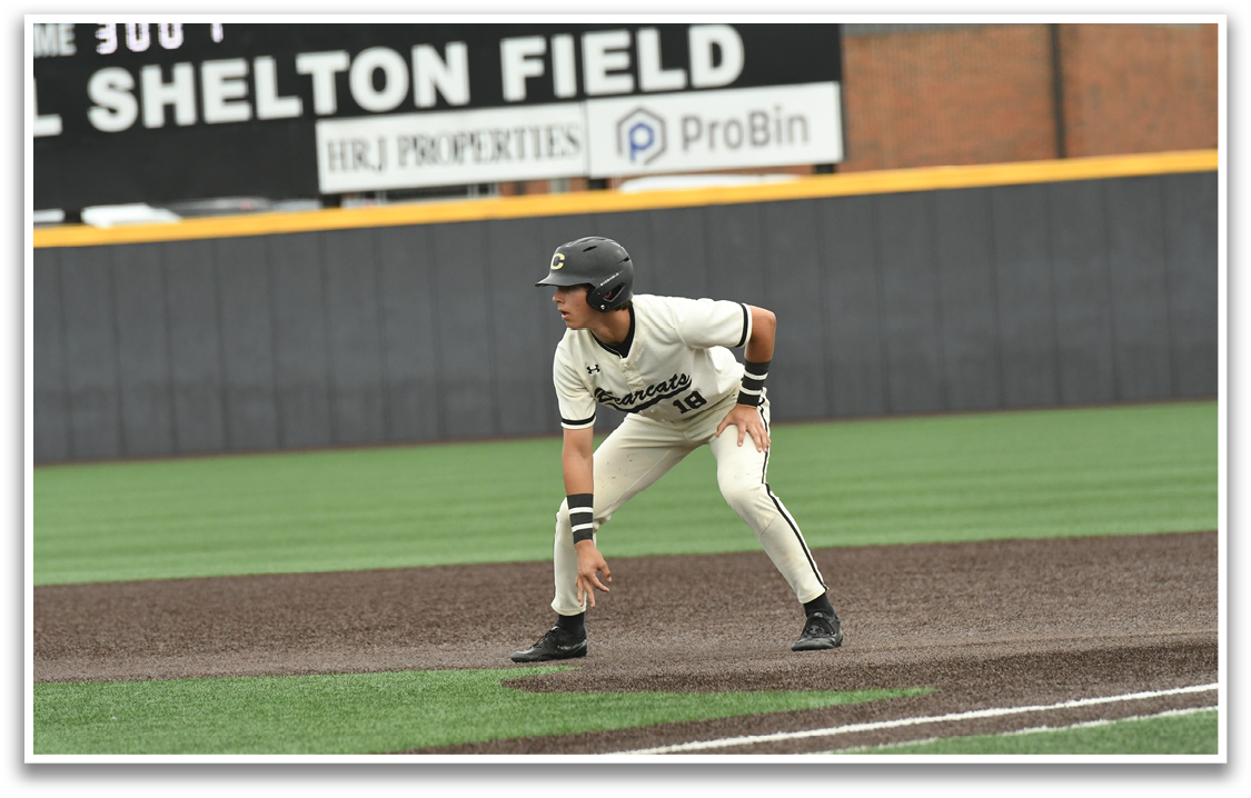 A baseball player in a white uniform is standing on a baseball field. Description generated by AI