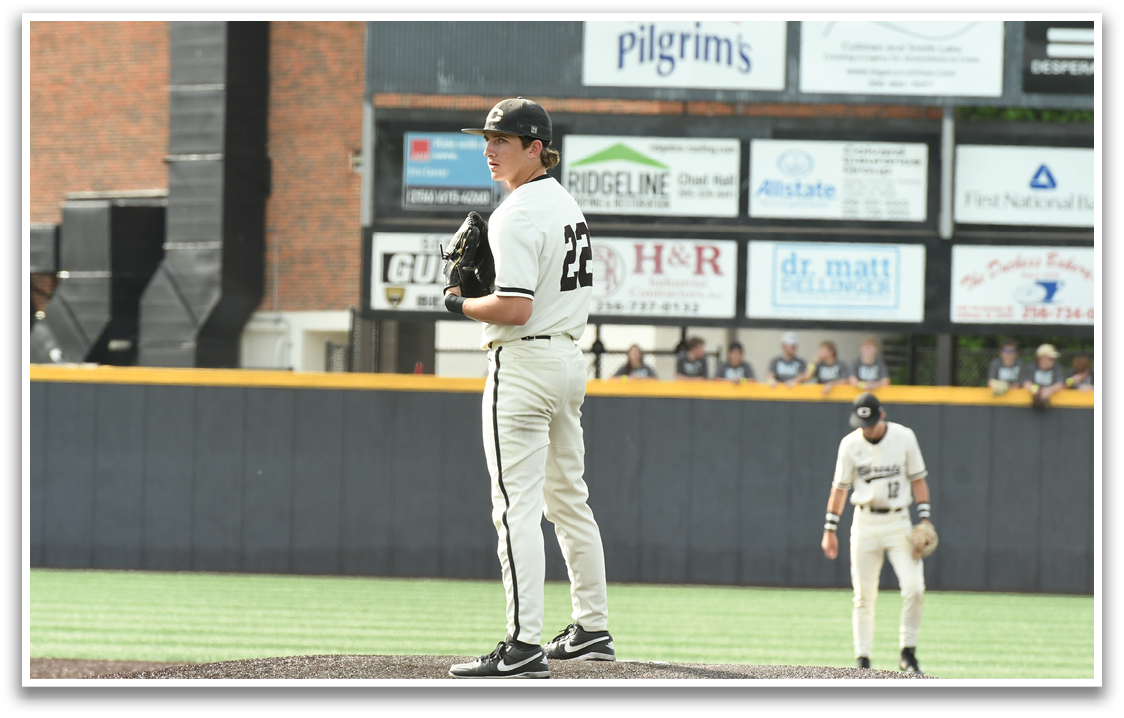 A baseball player standing on the pitcher's mound. Description generated by AI