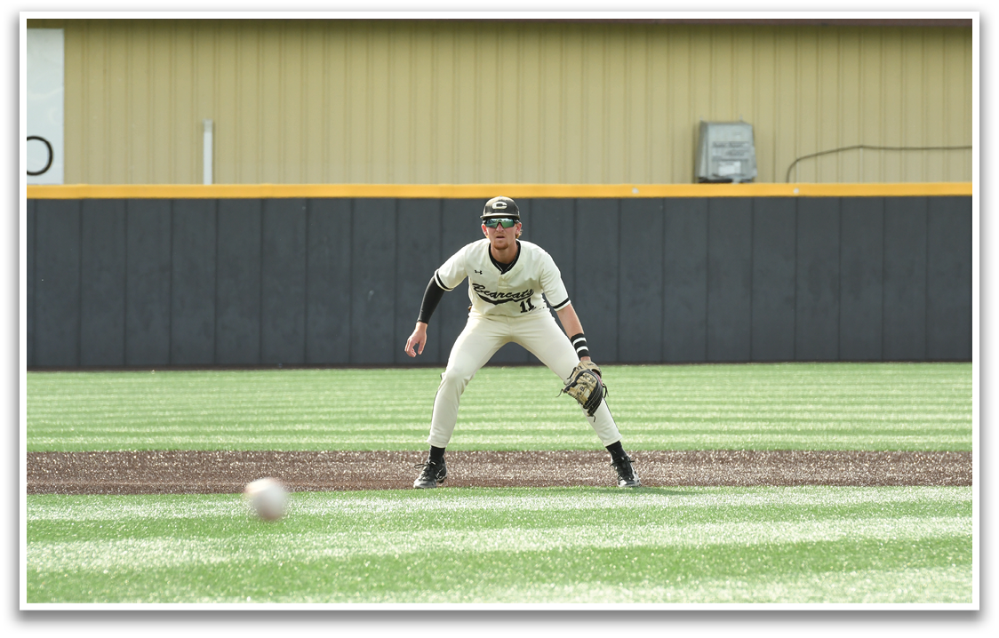 A baseball player in a white uniform is preparing to catch a ball. Description generated by AI