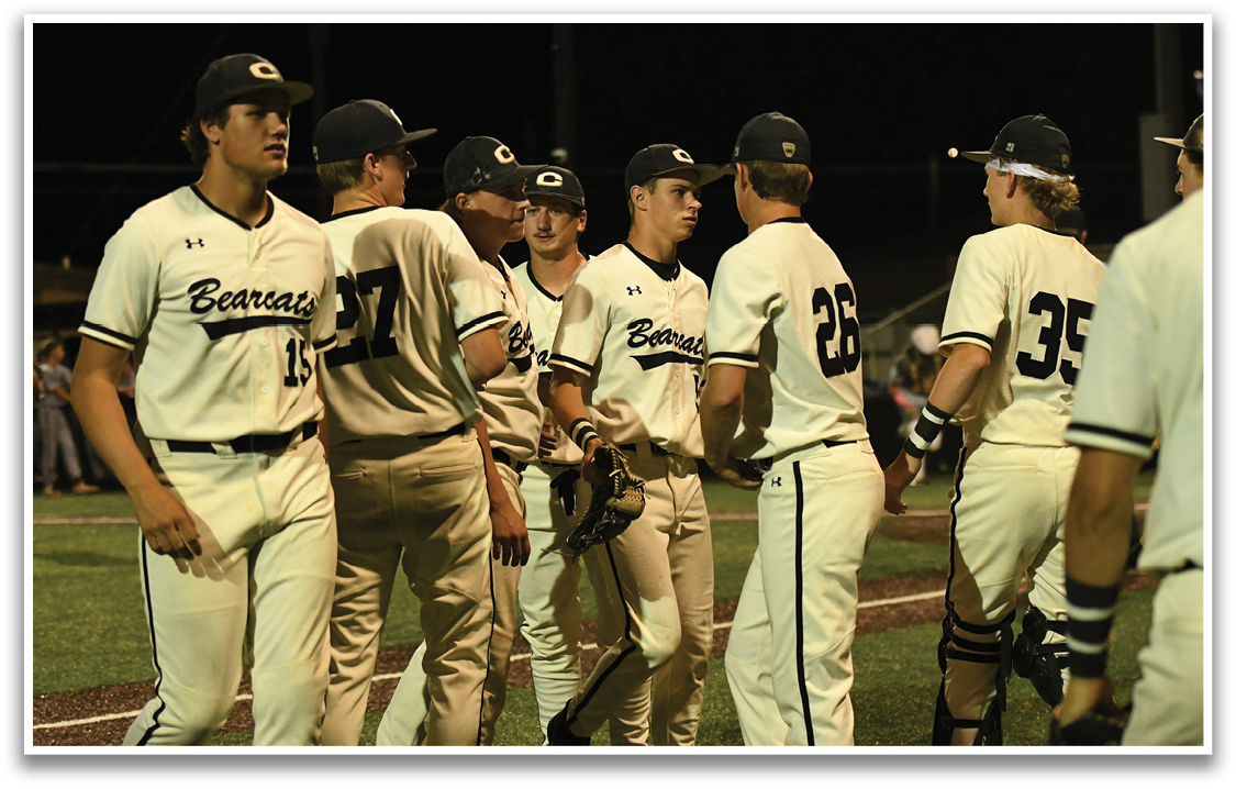 A group of baseball players wearing white uniforms. Description generated by AI