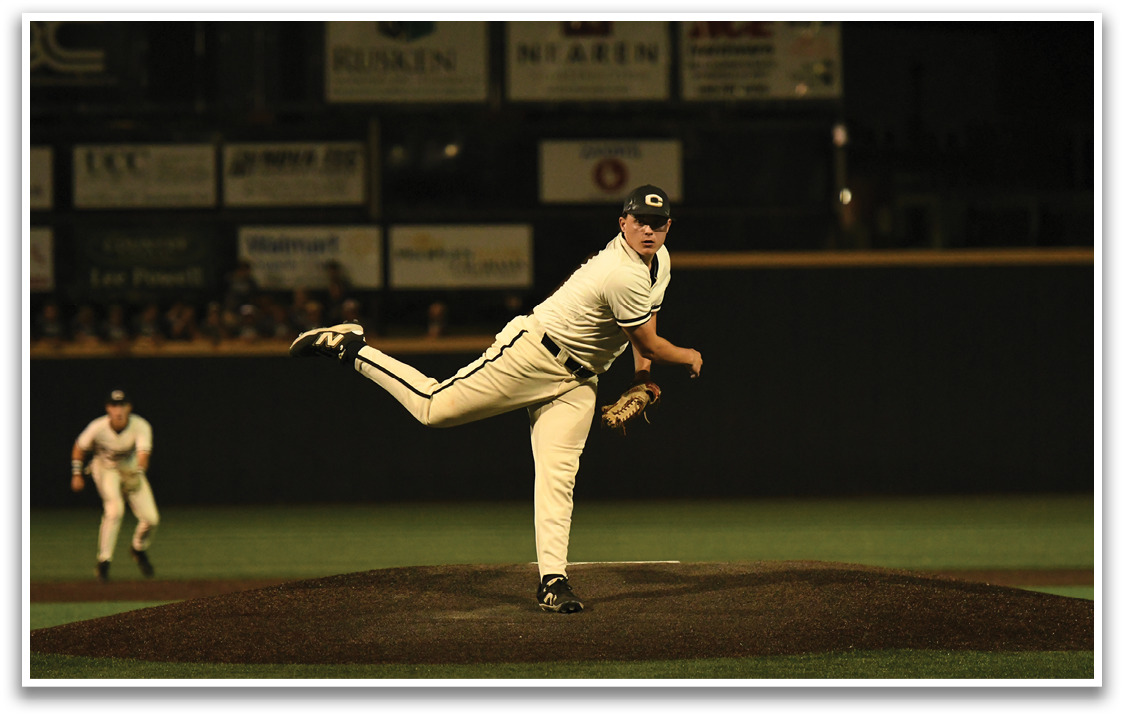 A baseball player in a white uniform is pitching a ball. Description generated by AI