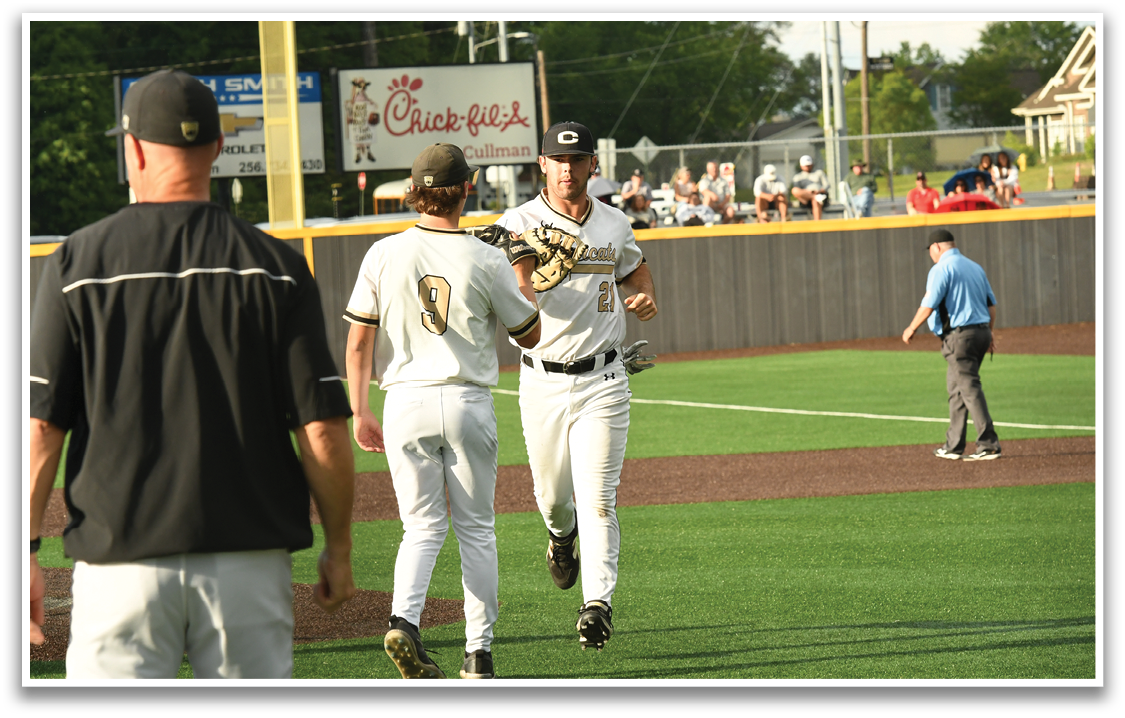 Two baseball players shake hands on the field. Description generated by AI