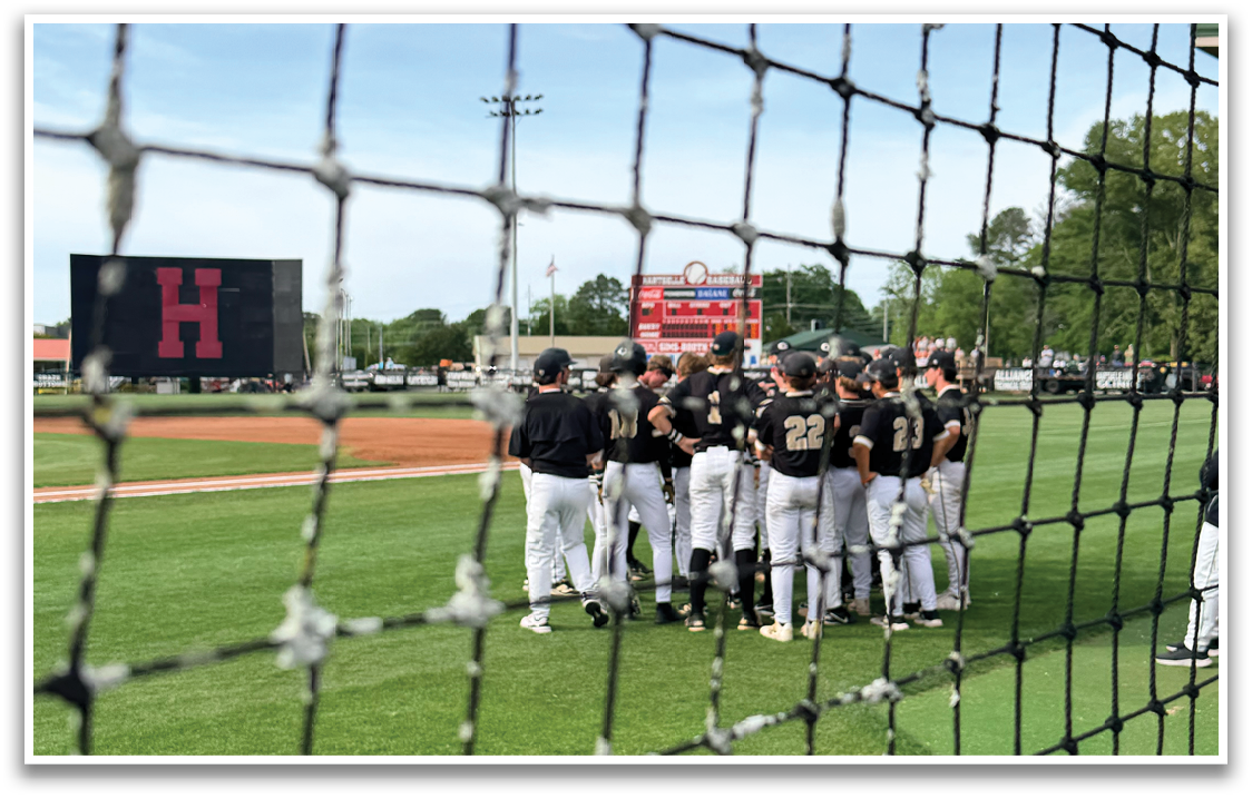 A group of baseball players standing on a field. Description generated by AI