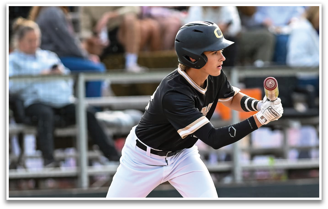 A baseball player in a black and white uniform is holding a bat and getting ready to swing. Description generated by AI