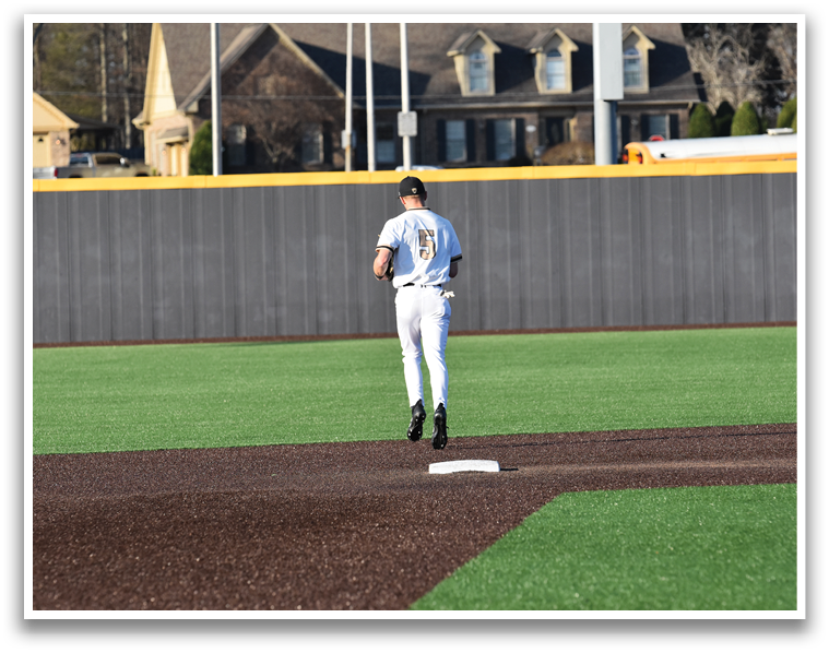 A baseball player is standing on the field, holding a baseball bat, and looking at the ground. AI generated content