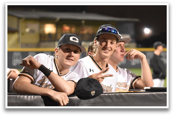 Two baseball players wearing black and white uniforms are sitting on a fence. AI generated content
