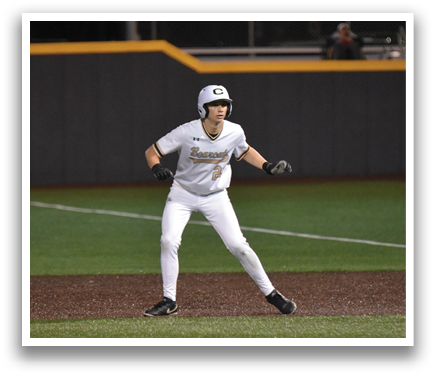 A woman wearing a white uniform is standing on a baseball field, holding a baseball bat. AI generated content